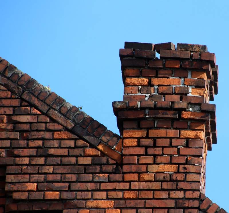Damaged chimney on an Capistrano Beach home showing cracks and missing mortar